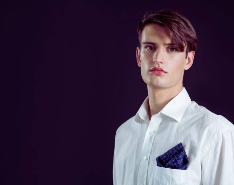 Une personne portant un look androgyne avec un mélange de vêtements masculins et féminins, des coupes de cheveux courtes et des accessoires minimalistes, reflétant l'élégance intemporelle du style androgyne en 2022.
